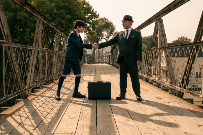 Number Five from The Umbrella Academy shaking hands with a man