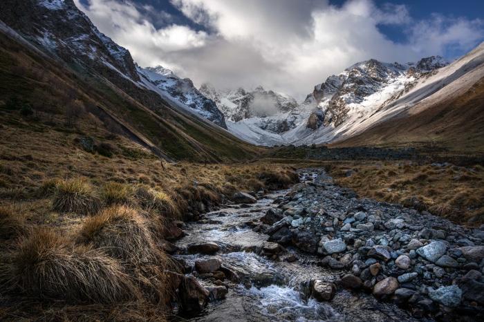 Mountain valley with a river and snow-capped peaks