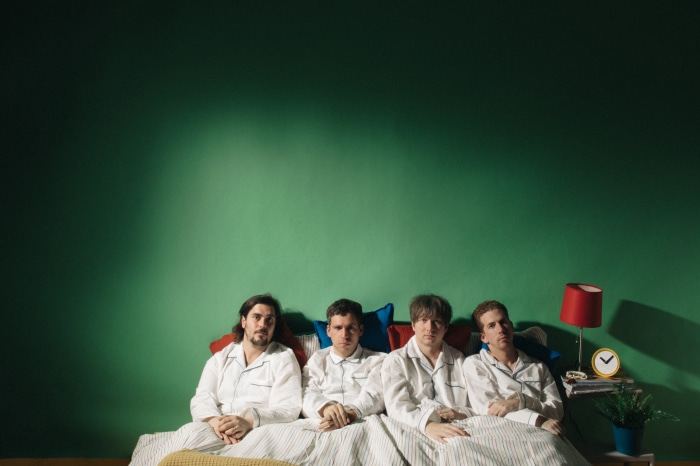 Parquet Courts band members in pajamas on a bed