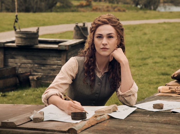 Woman from Outlander drawing at a table