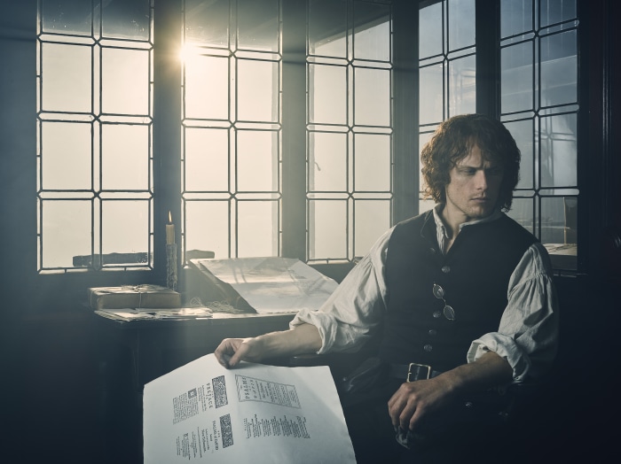 Jamie Fraser from Outlander reading a document