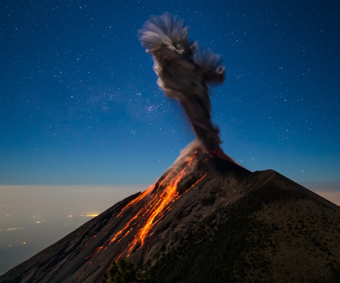 Volcano Erupting Lava and Ash Under Starry Night Sky