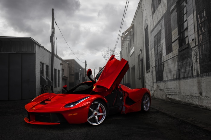 Red Ferrari LaFerrari with doors open in alley