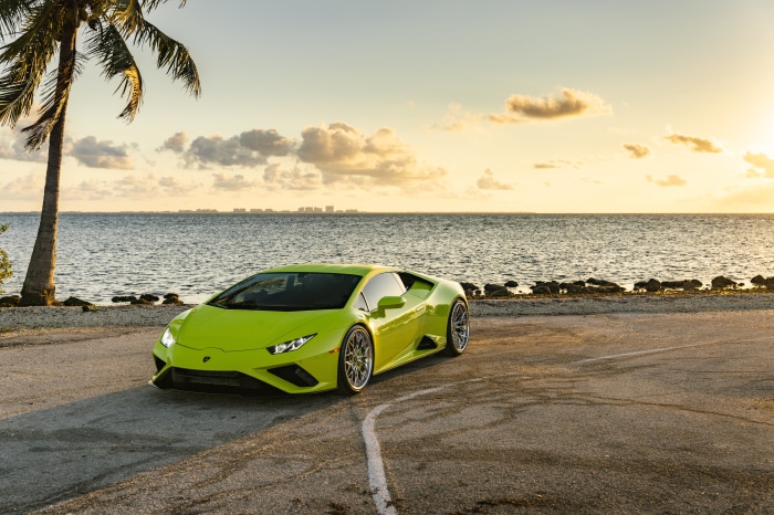 Green Lamborghini Huracan Evo by the ocean at sunset