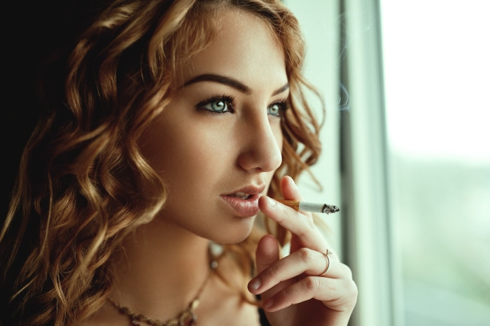 Woman with curly hair smoking a cigarette