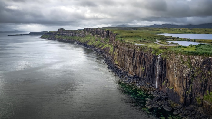 Waterfall cascading down a cliff face into the sea