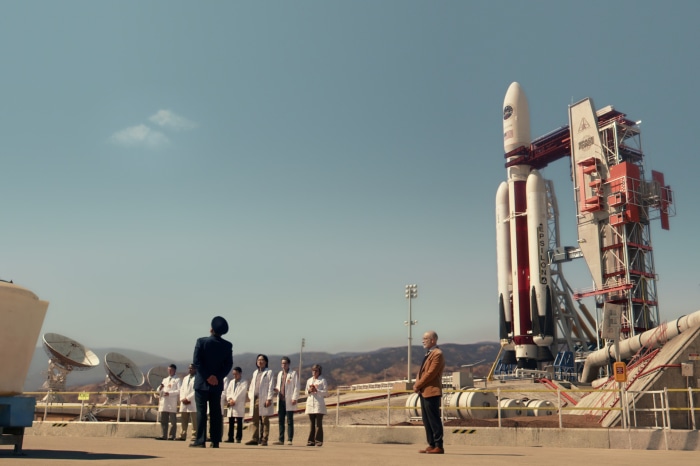 John Malkovich and scientists at a rocket launch site