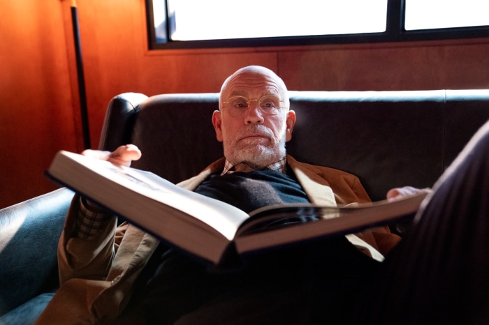 John Malkovich reading a book