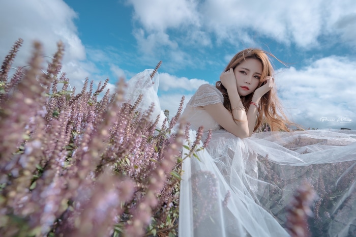 Asian woman in white dress in flower field