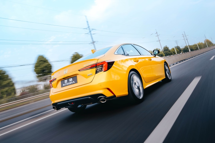 Yellow Honda Integra driving on a highway
