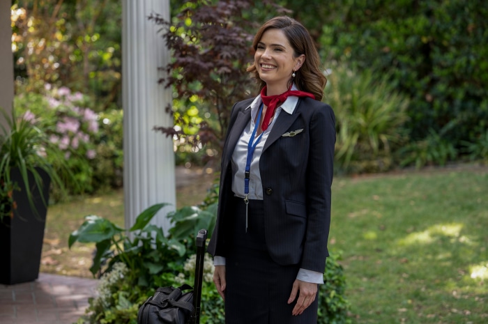 Woman in flight attendant uniform with luggage