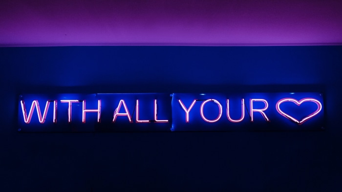 Neon sign with text "WITH ALL YOUR HEART"