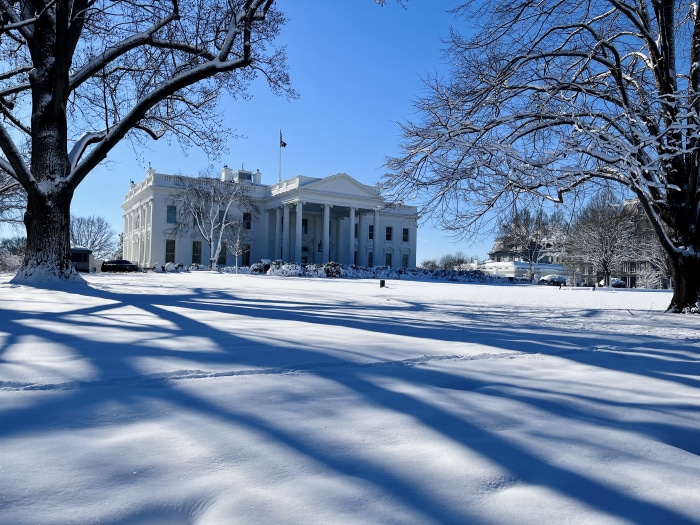The White House covered in snow under a clear blue sky