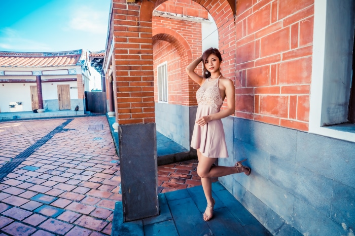 Asian Woman in Dress Posing by Brick Archway