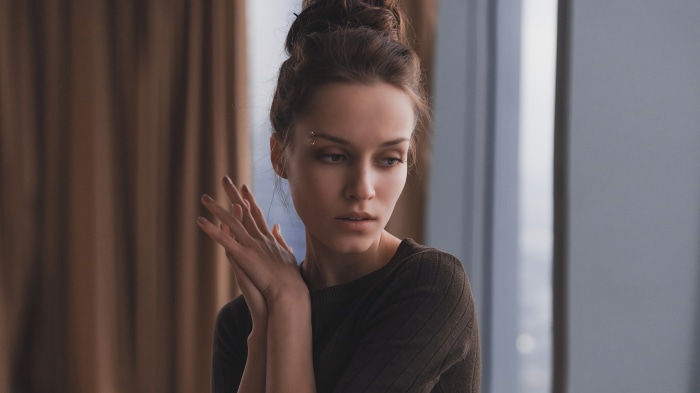 Woman with hair bun and eyebrow piercing