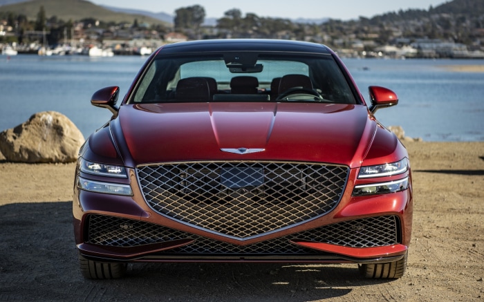 Red Genesis G80 Sedan parked by the water