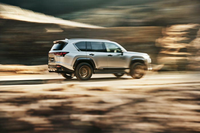 Silver Lexus LX 600 SUV driving on a dirt road