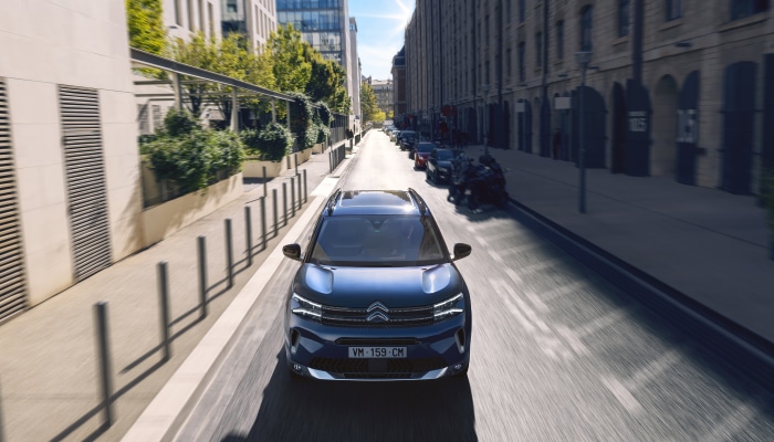 Blue Citroen C5 Aircross driving on a city street