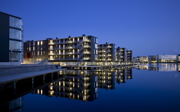 Modern apartment buildings reflected in water at night