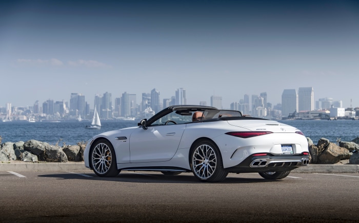 White Mercedes-AMG SL Cabriolet parked by the water with city skyline