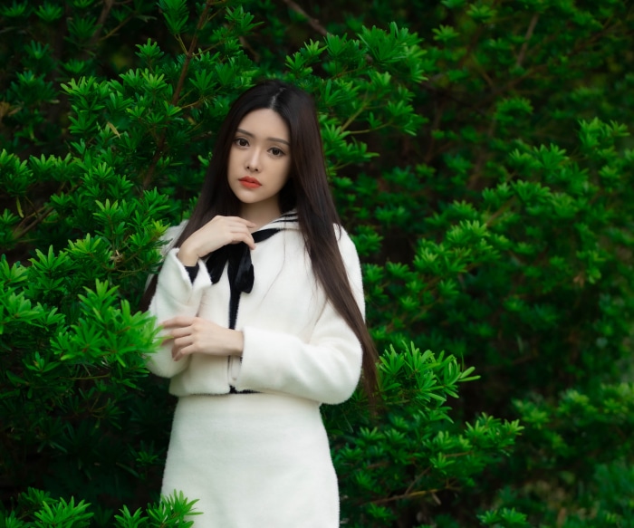 Asian woman with black hair in white outfit