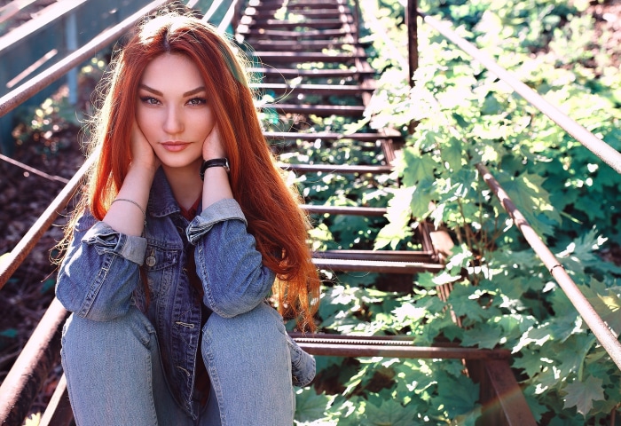 Redhead woman sitting on metal stairs