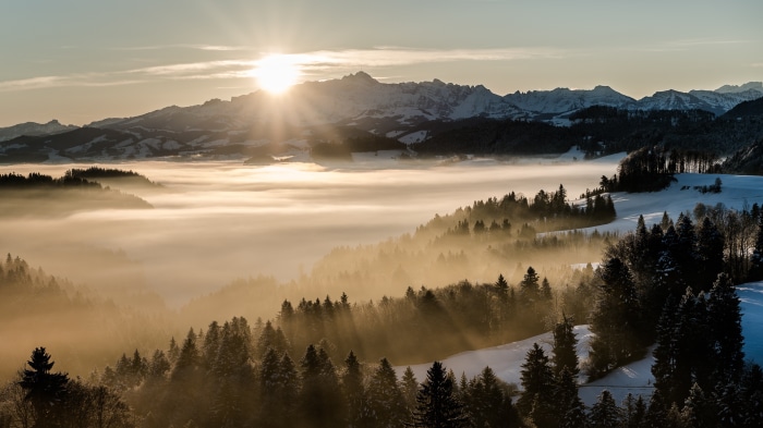 Sunrise over a foggy mountain landscape with snow
