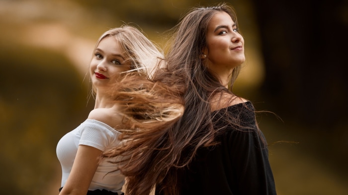 Two young women with long hair outdoors