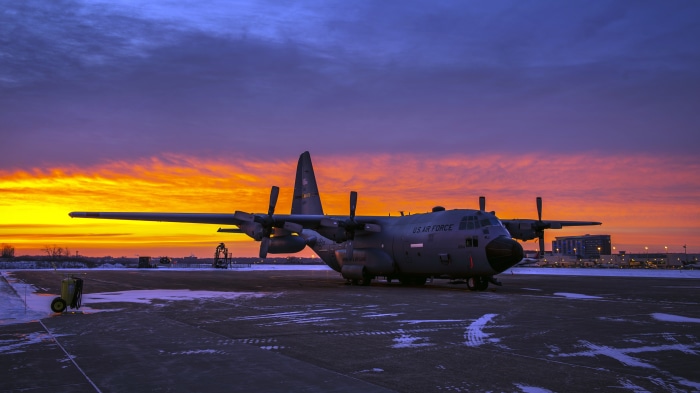 Lockheed C-130 Hercules transport aircraft at sunrise
