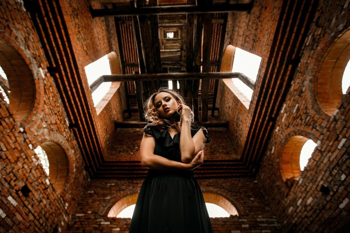Woman in black dress in brick building