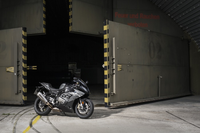 Black BMW S1000RR motorcycle in front of hangar doors