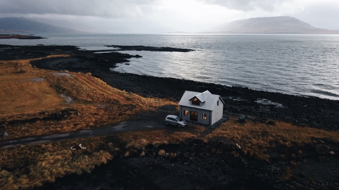 House and car by the sea in Hvalfjörður, Iceland