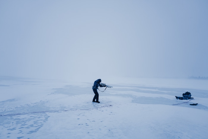 Man with rifle in snowy landscape