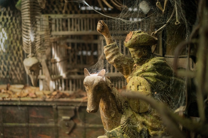 Statue of a man on a horse covered in cobwebs