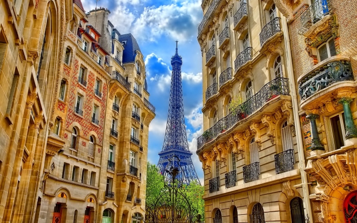 Eiffel Tower view between Parisian buildings