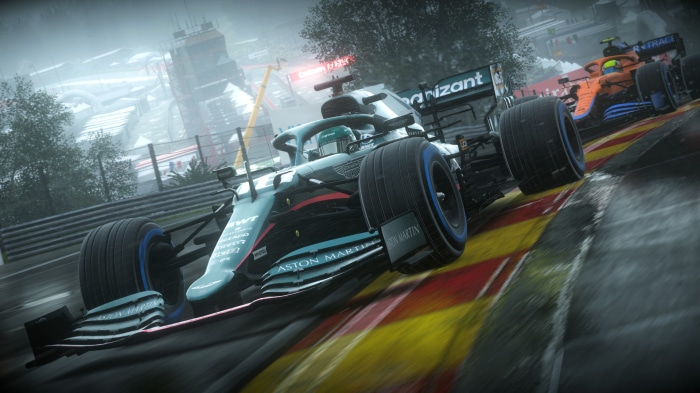 Aston Martin and McLaren F1 cars racing on a wet track