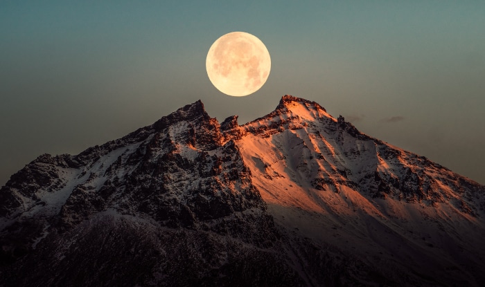 Moonrise over snow-capped mountains in Iceland