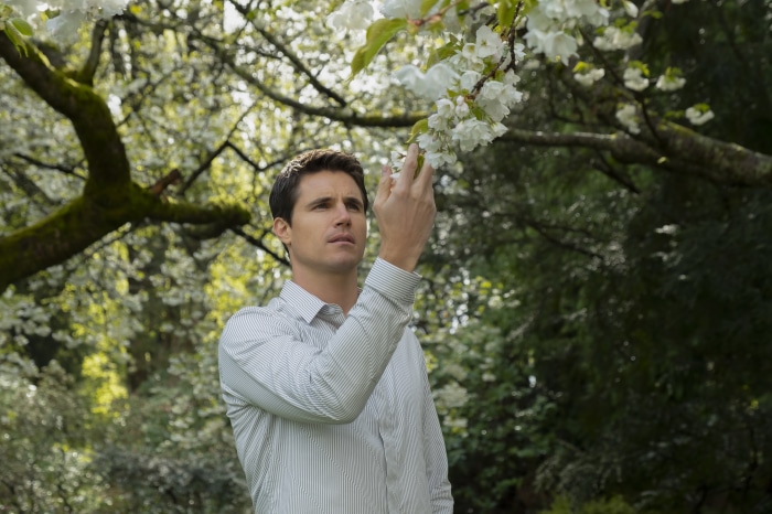 Robbie Amell in a garden
