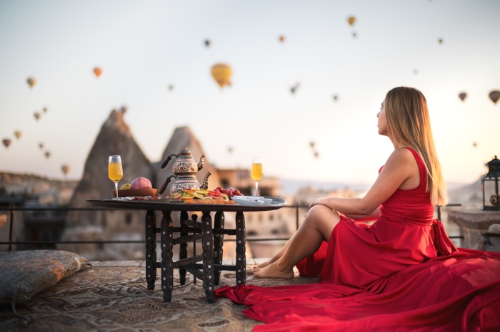 Woman in red dress with breakfast and hot air balloons