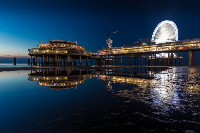 Pier at night with Ferris wheel and reflection