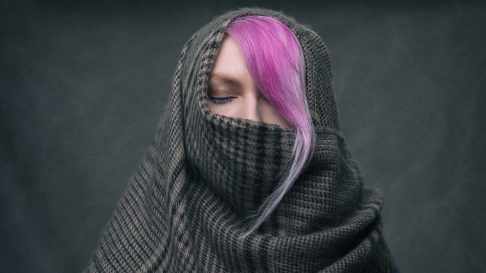 Woman with pink hair covered by a scarf