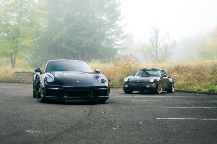 Two black Porsche 911 Turbo cars parked
