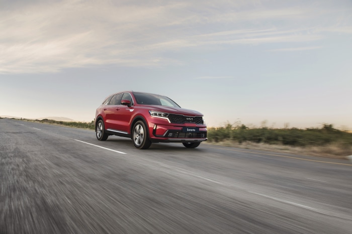 Red Kia Sorento SUV driving on a road
