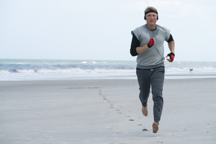 Johnny Lawrence from Cobra Kai running on the beach