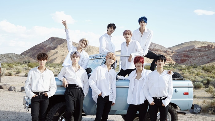 NCT members posing in desert with a vintage truck