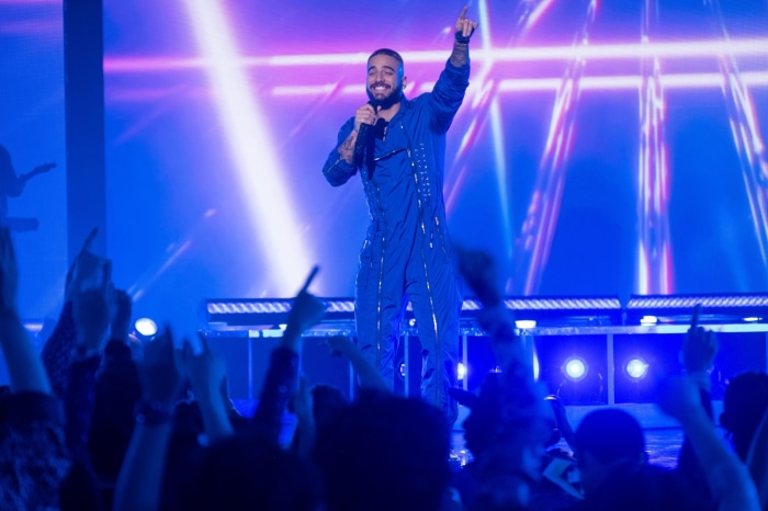 Maluma performing on stage with audience