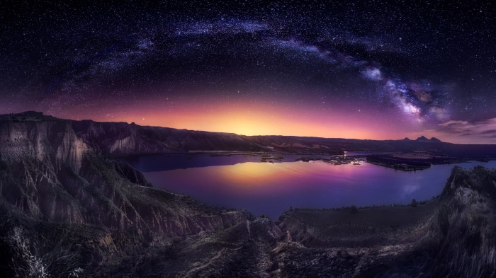 Milky Way over a lake and mountains at night