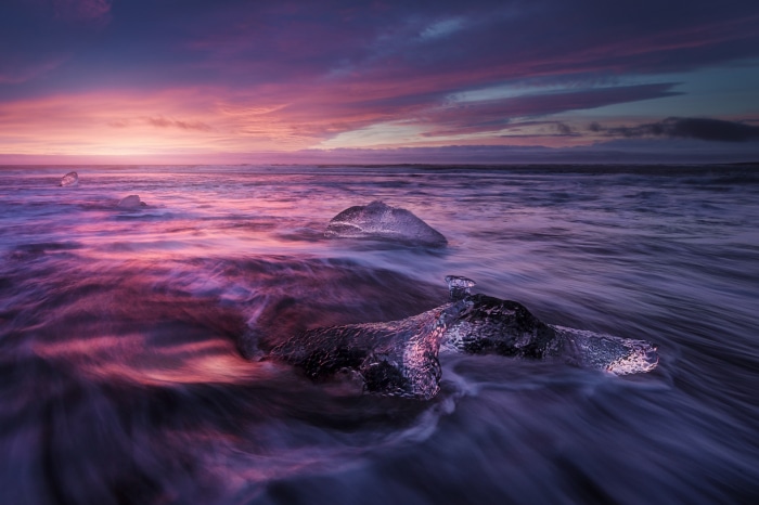 Icebergs on a beach at sunset