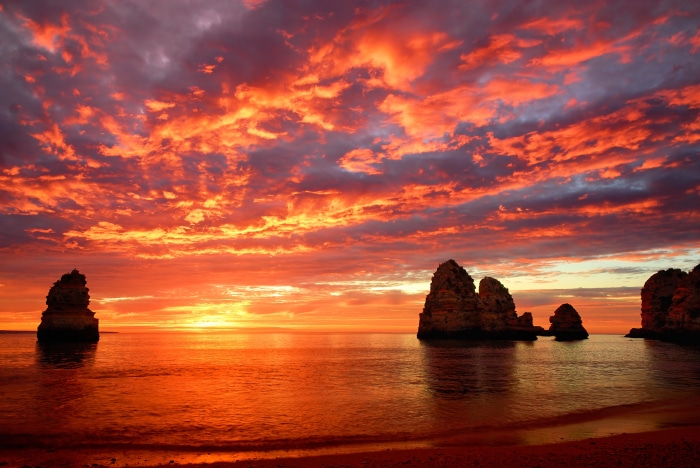 Dramatic Sunset Over Ocean With Rock Formations