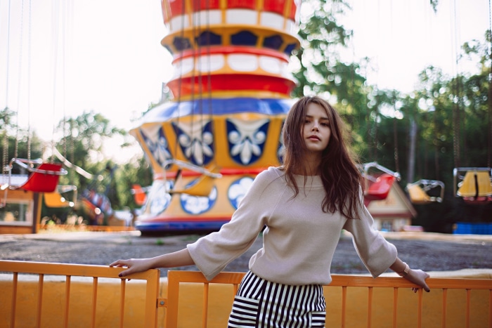 Young woman in striped skirt at amusement park